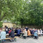 Corona auf dem Bürgerfrühschoppen 2026. Menschen auf Bierbänken vor der Organgerie.