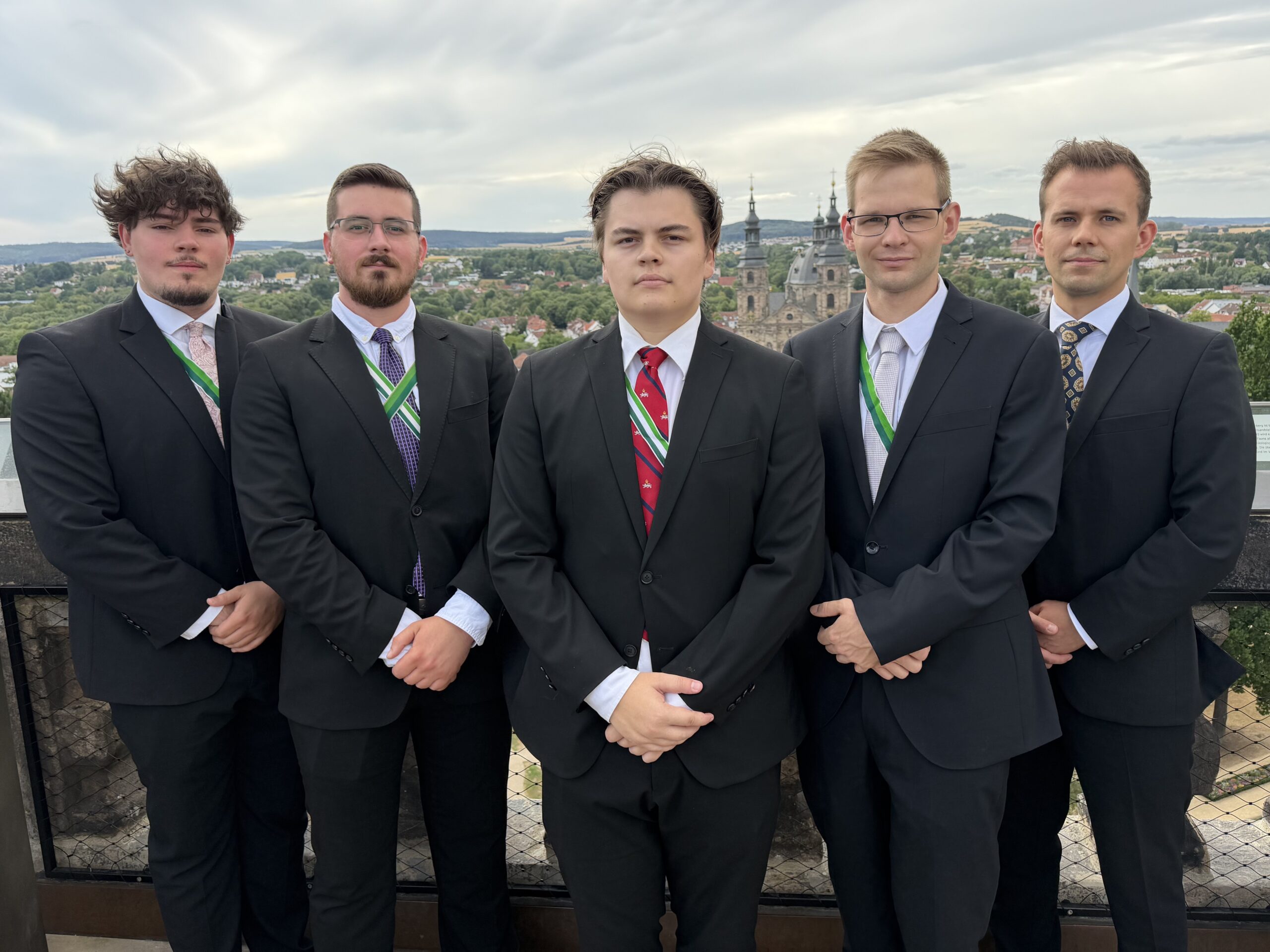 Die Chargen des Wintersemester 2026/27 posieren auf dem Turm des Stadtschlosses mit dem Dom im Hintergrund.